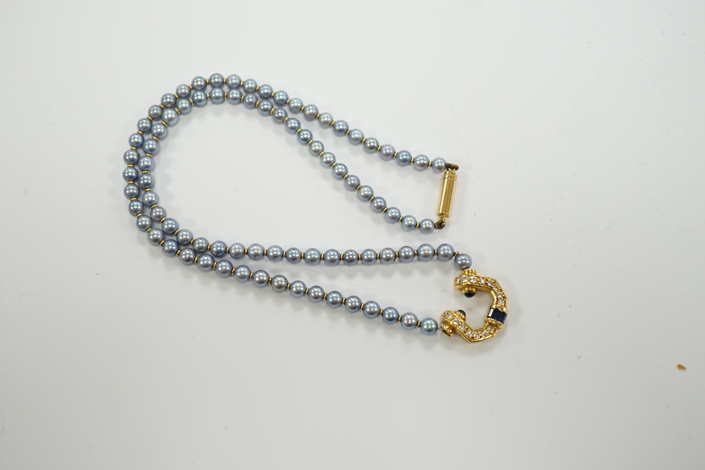 A modern single strand blue cultured pearl necklace, with 750 yellow metal, sapphire and diamond set pendant and yellow metal clasp, 42cm.